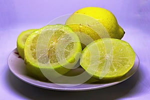 Pictures of sliced Ã¢â¬â¹Ã¢â¬â¹lemon fruit on a plate  on a white background photo
